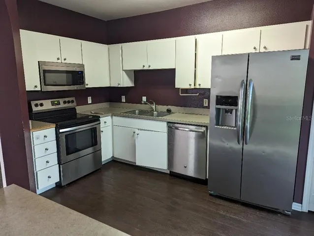 a kitchen with stainless steel appliances a refrigerator sink and microwave