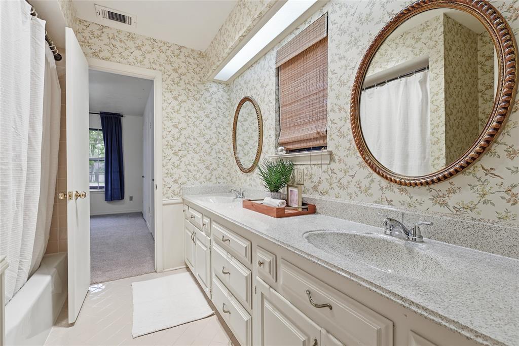 823 Ridgecrest Circle Denton, TX 76205 - Photo 26 of 40 Double vanity featuring white cabinetry and light-toned countertops with integrated sinks