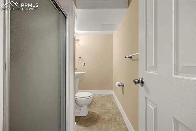 a bathroom with a granite countertop shower and a toilet