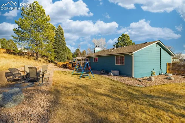 a backyard of a house with table and chairs