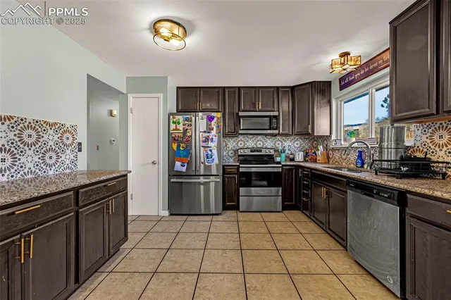 a kitchen with stainless steel appliances granite countertop a refrigerator and a stove top oven