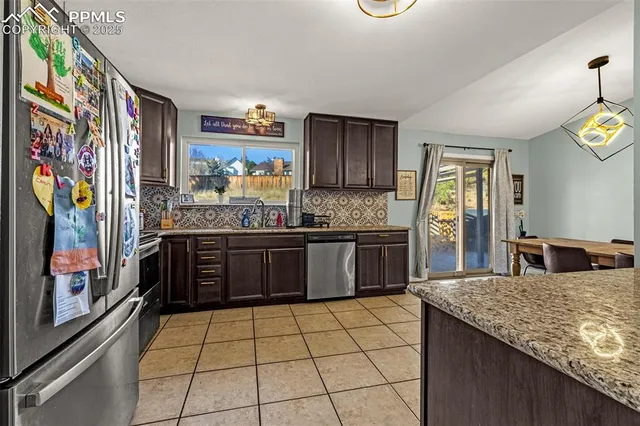 a kitchen with stainless steel appliances granite countertop a stove a sink and a refrigerator