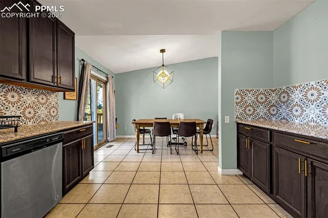 a kitchen with granite countertop a sink cabinets and stainless steel appliances