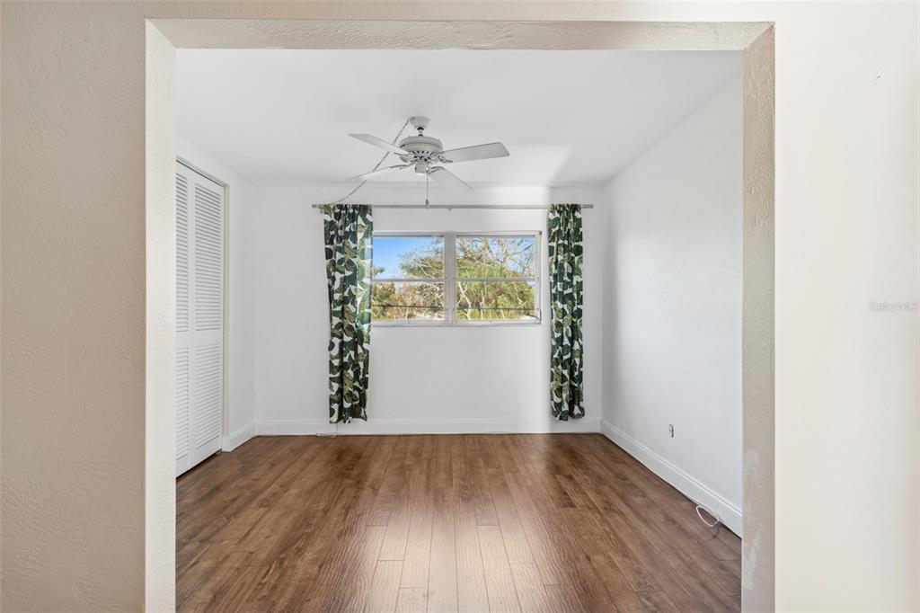 4565 Duhme Road, Unit 203 St. Petersburg, FL 33708 - Photo 16 of 27 an empty room with wooden floor chandelier and windows