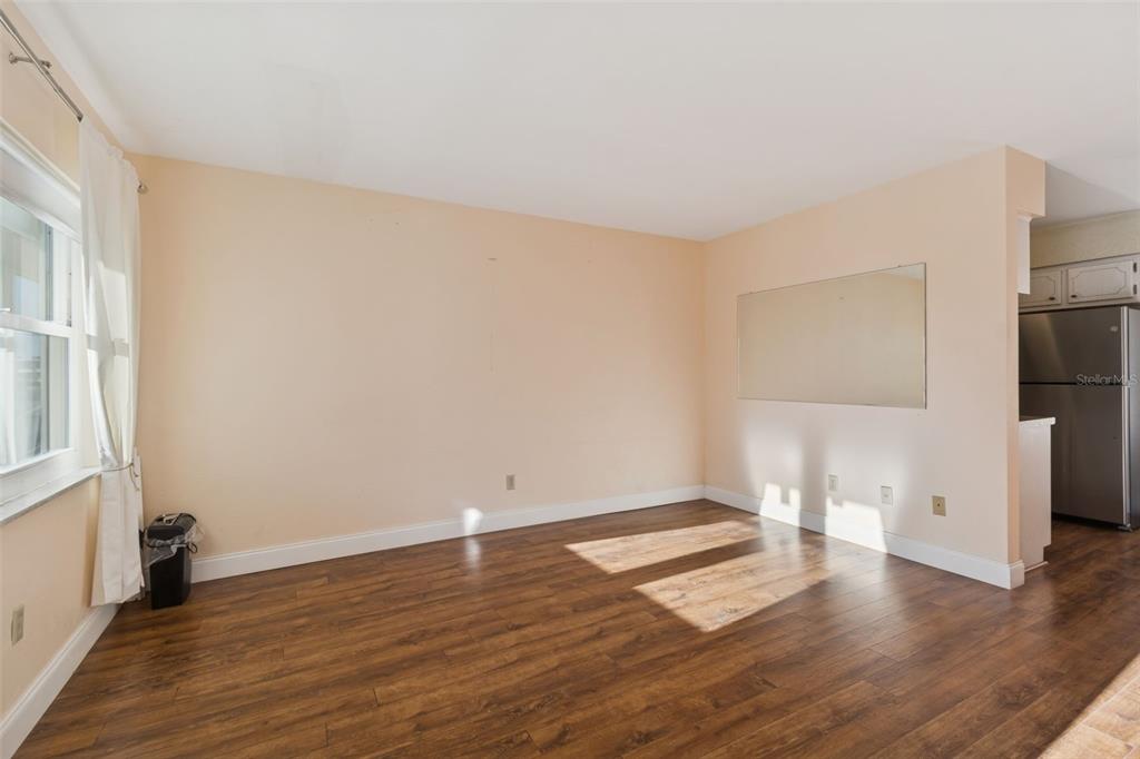 4565 Duhme Road, Unit 203 St. Petersburg, FL 33708 - Photo 4 of 27 a view of empty room with wooden floor and window