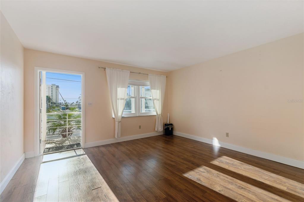 4565 Duhme Road, Unit 203 St. Petersburg, FL 33708 - Photo 5 of 27 an empty room with wooden floor and windows