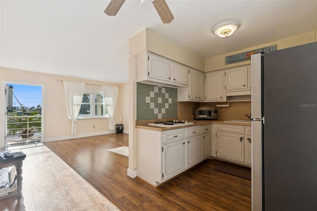4565 Duhme Road, Unit 203 St. Petersburg, FL 33708 - Photo 7 of 27 a kitchen with granite countertop a stove a sink dishwasher and a refrigerator with wooden floor