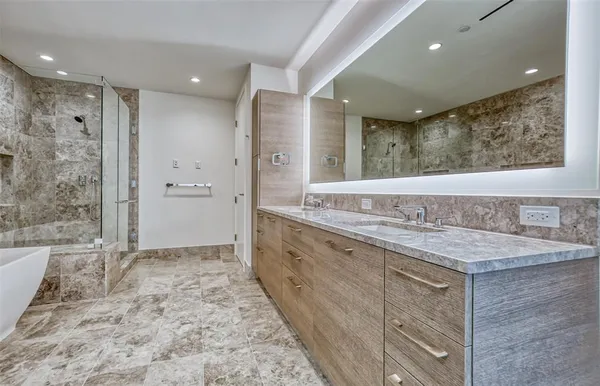 a bathroom with a granite countertop sink mirror and shower