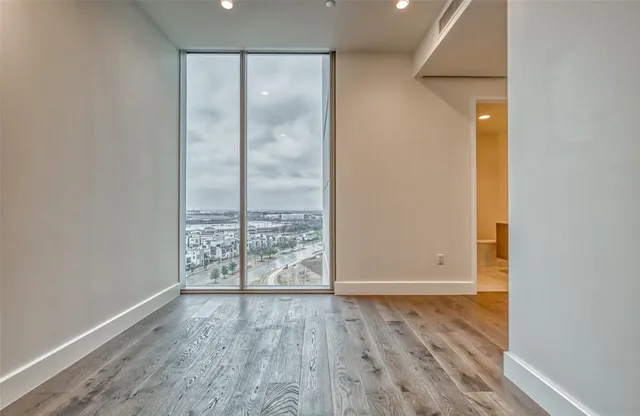 an empty room with wooden floor and door