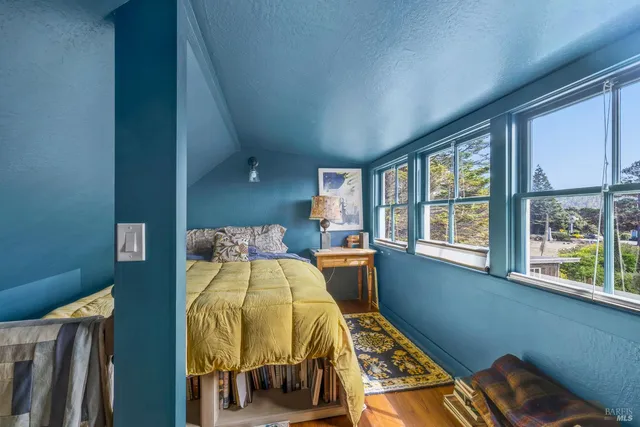 a bed sitting in a bedroom next to a window