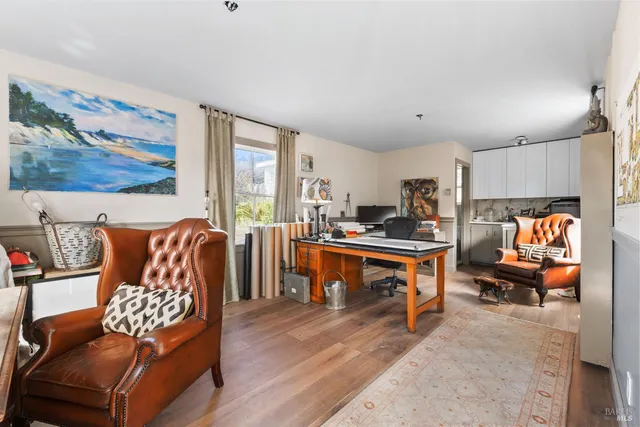 a living room with furniture kitchen view and a large window