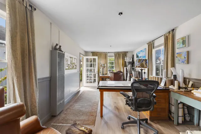 a view of a livingroom with workspace and windows