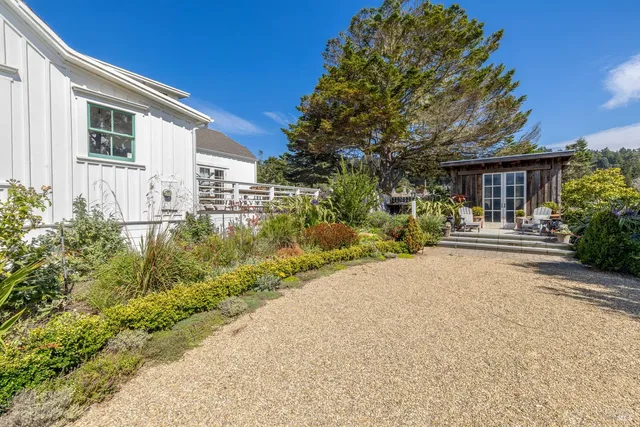 a front view of a house with a yard and potted plants