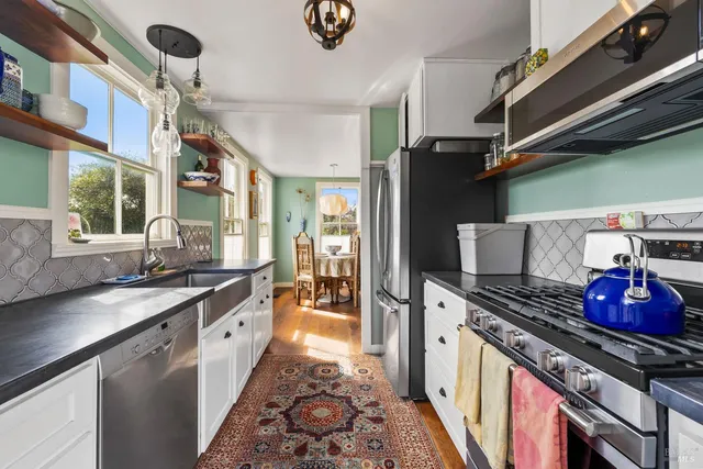 a kitchen with stainless steel appliances granite countertop a stove and cabinets