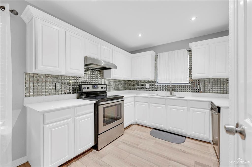 1409 Heritage Oaks Road Edinburg, TX 78539 - Photo 3 of 18 a kitchen with granite countertop white cabinets and white appliances