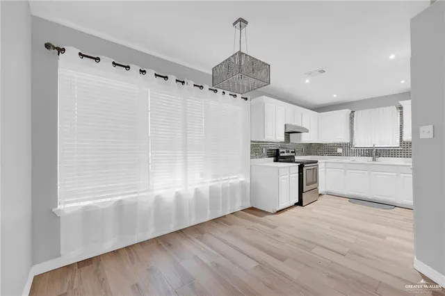 a kitchen with a refrigerator a sink and cabinets
