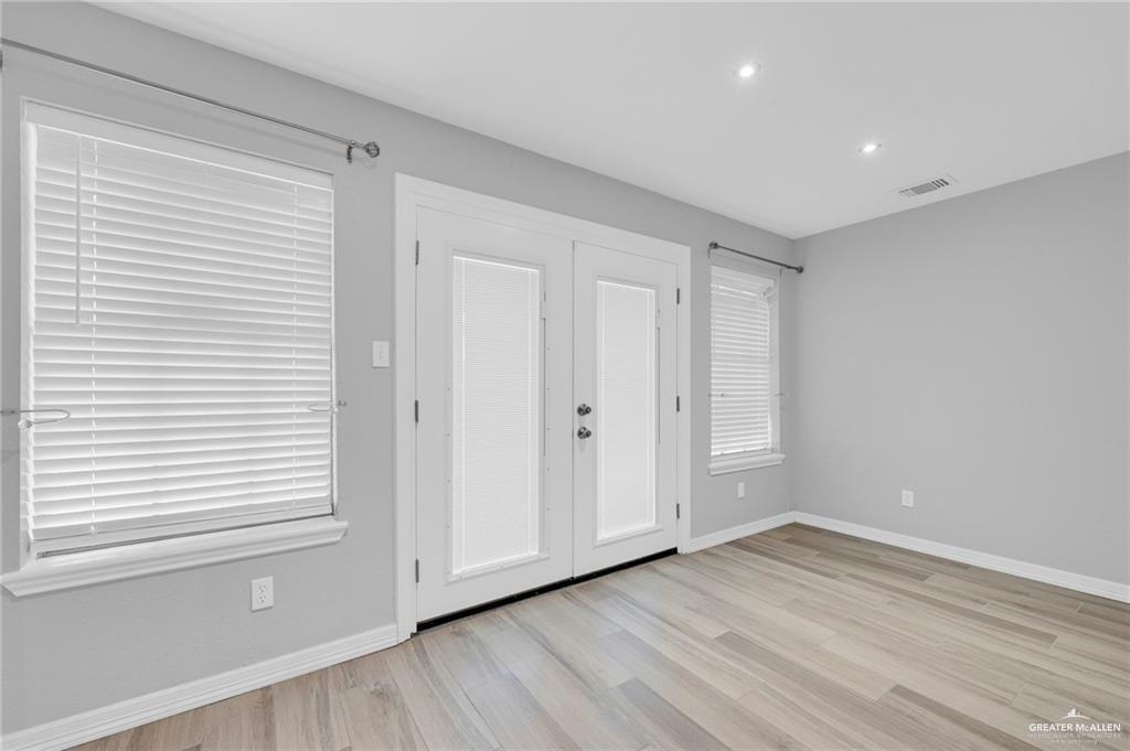 1409 Heritage Oaks Road Edinburg, TX 78539 - Photo 7 of 18 a view of an empty room with wooden floor and a window