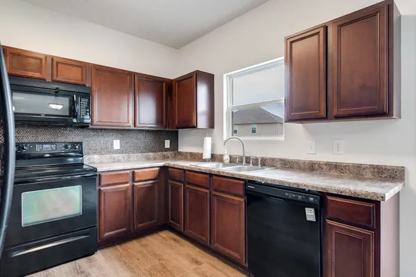 a kitchen with granite countertop wooden cabinets and stainless steel appliances