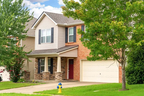 a front view of a house with a yard and trees