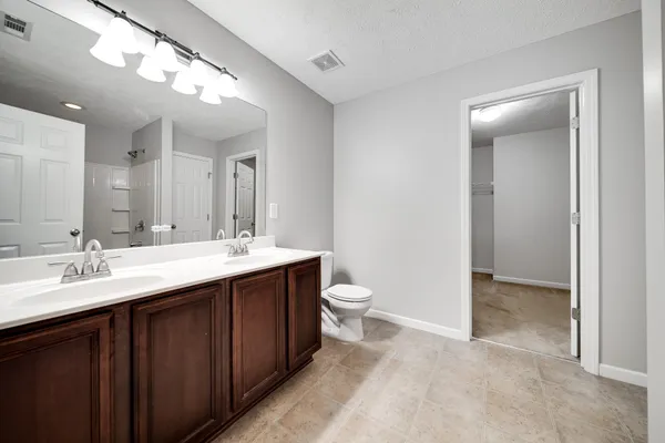 a bathroom with a sink a toilet and shower curtain