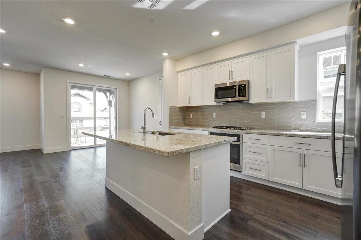12101 Almeria Way San Ramon, CA 94583 - Photo 12 of 44 a kitchen with stainless steel appliances granite countertop a sink stove and microwave
