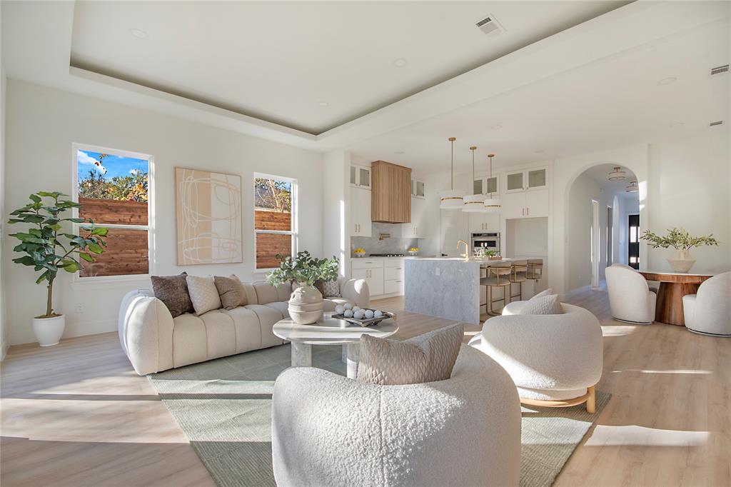 3902 Furey Street Dallas, TX 75212 - Photo 10 of 34 Living area featuring arched walkways, a raised ceiling, and light wood-type flooring