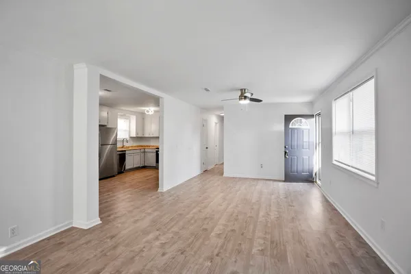 wooden floor in an empty room with a kitchen