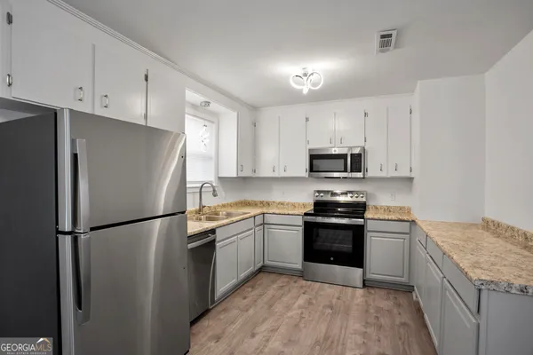 a kitchen with stainless steel appliances granite countertop a refrigerator stove a sink and dishwasher