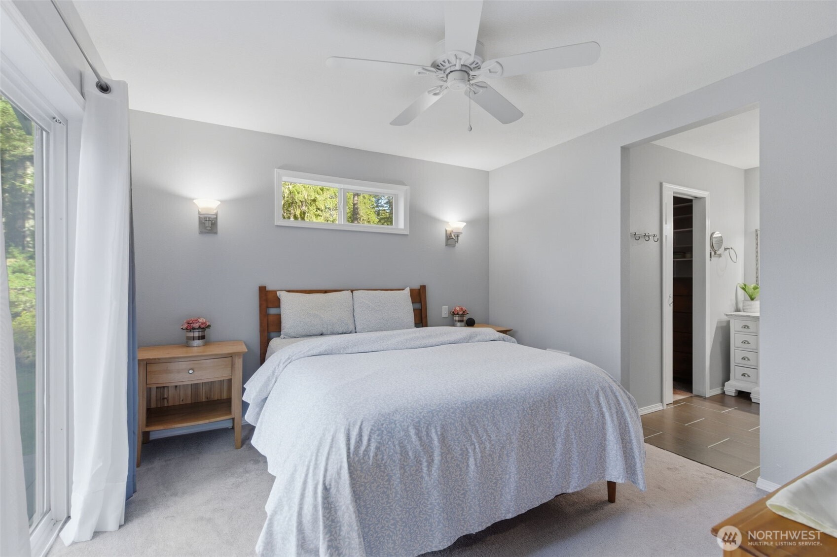 6971 Northeast Tahuya Blacksmith Road Belfair, WA 98528 - Photo 20 of 38 a bedroom with a bed and a chandelier