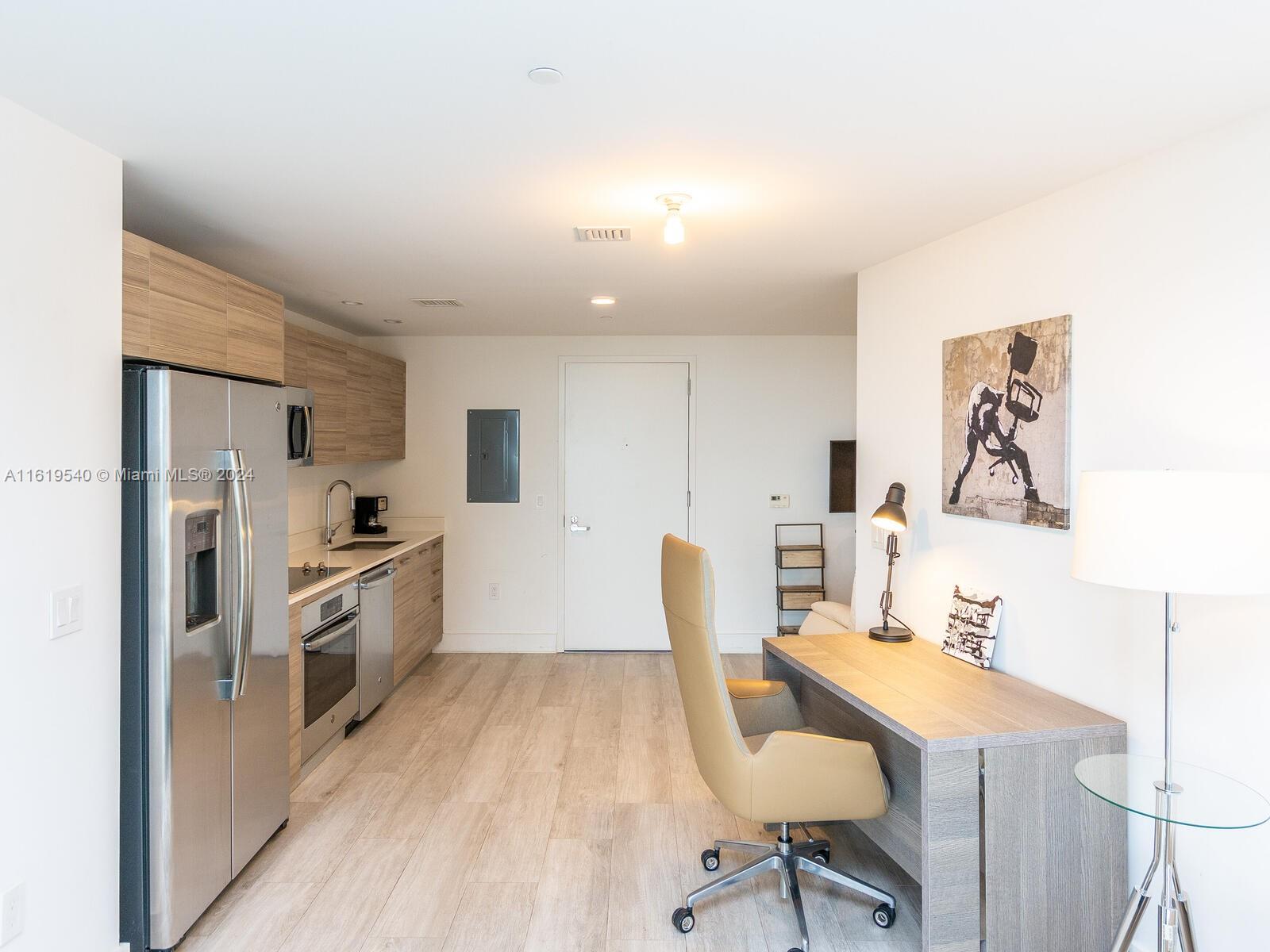 121 Northeast 34th Street, Unit 1014 Miami, FL 33137 - Photo 11 of 30 a kitchen with kitchen island a stove a table and chairs in it
