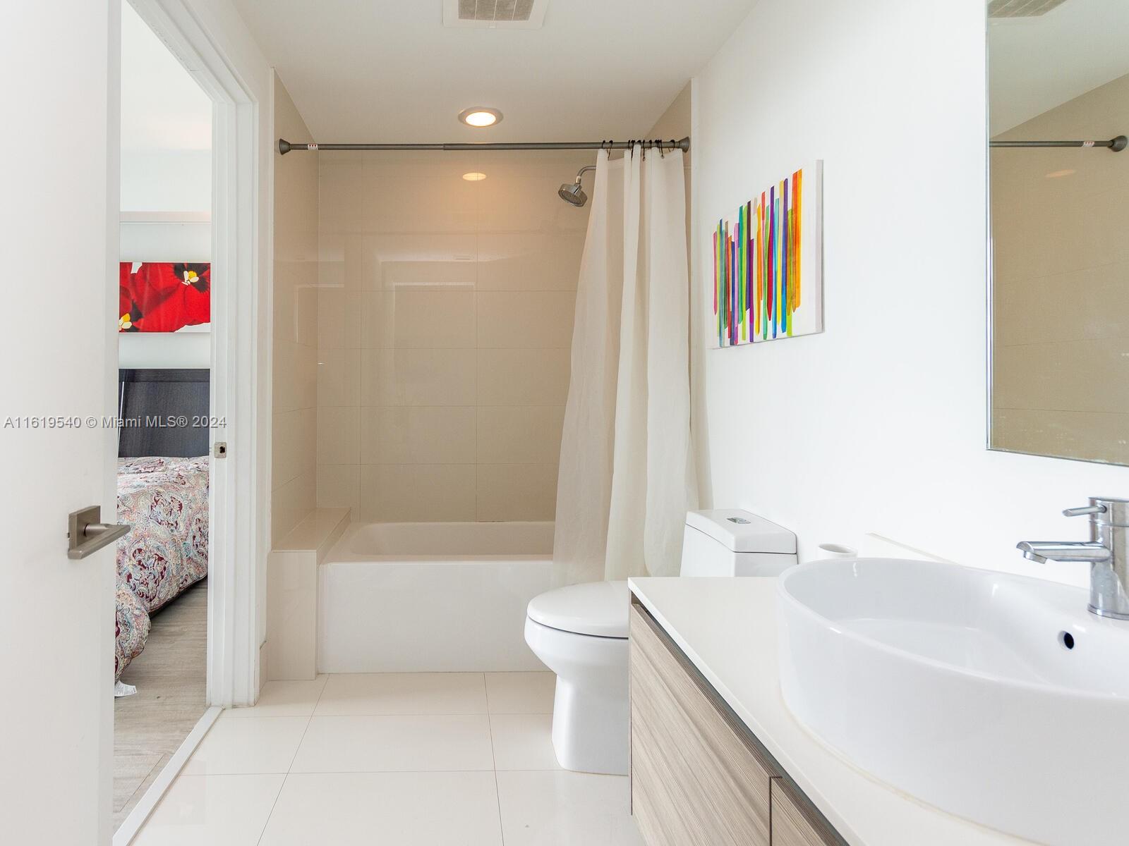 121 Northeast 34th Street, Unit 1014 Miami, FL 33137 - Photo 2 of 30 a bathroom with a sink a toilet and shower