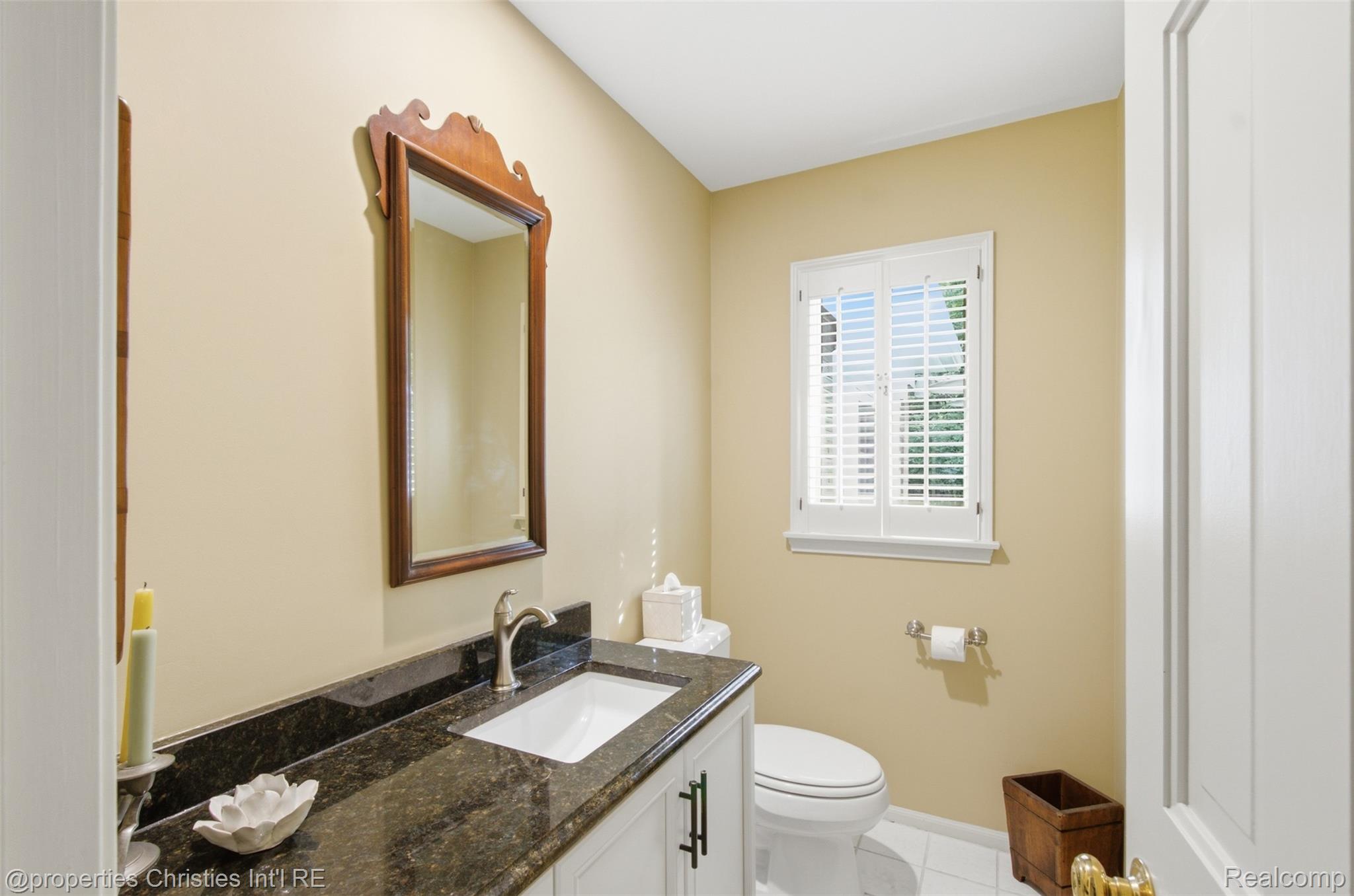 25235 Canterbury Road Franklin, MI 48025 - Photo 24 of 56 Family powder room has vanity with dark countertop, undermount sink, and brushed nickel faucet