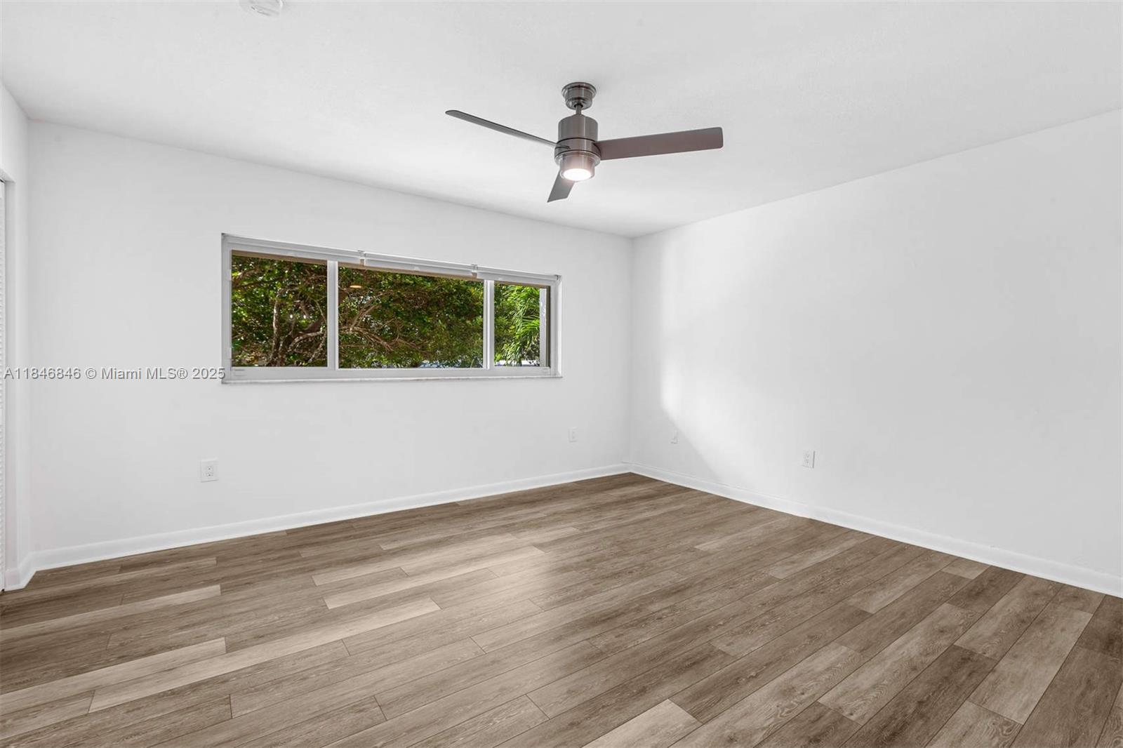 8218 Southwest 82nd Court Miami, FL 33143 - Photo 14 of 20 an empty room with wooden floor and windows