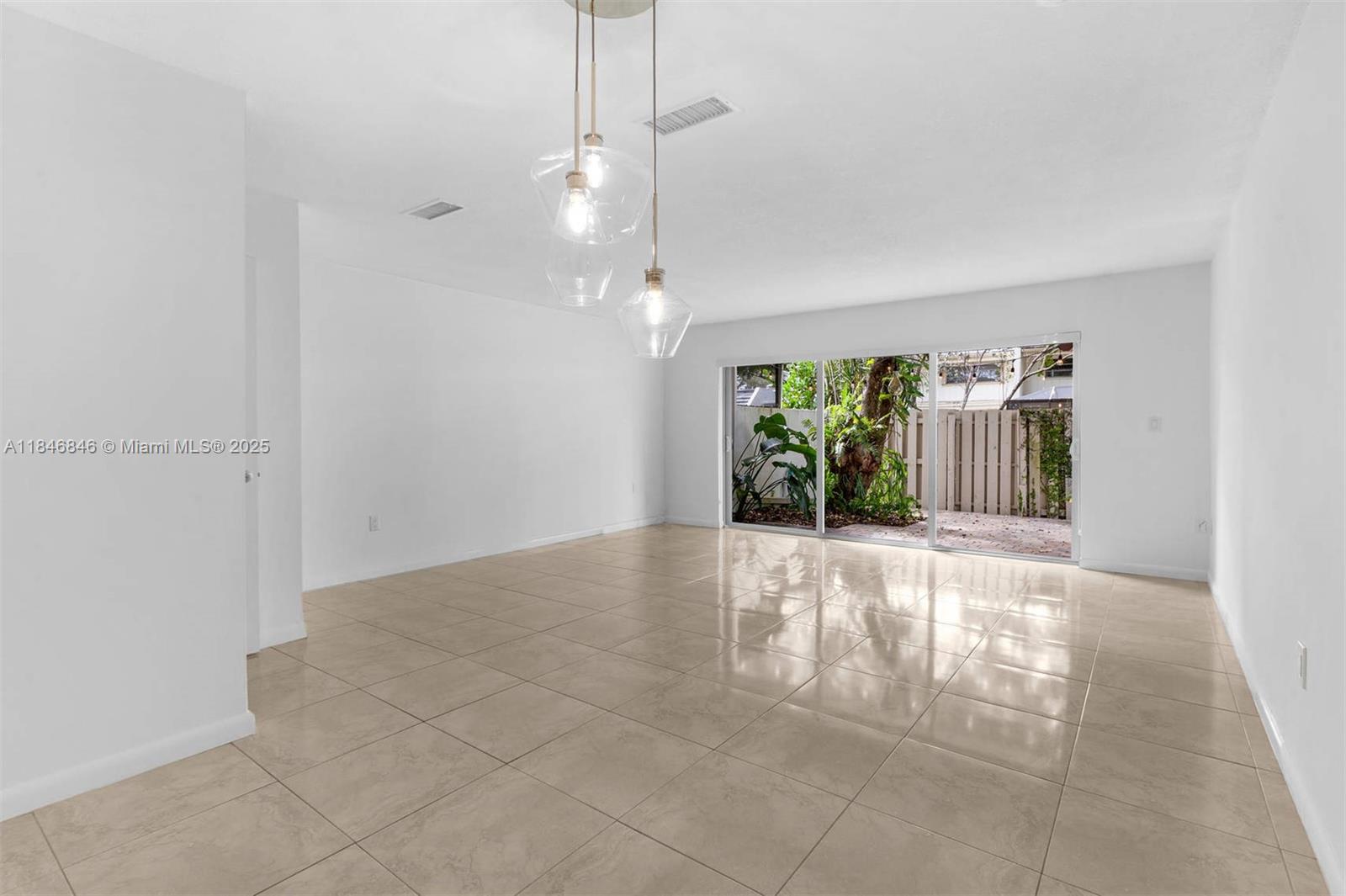 8218 Southwest 82nd Court Miami, FL 33143 - Photo 4 of 20 a view of an empty room with window and chandelier fan