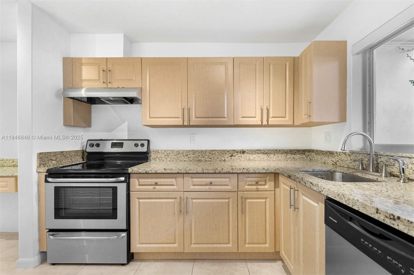 8218 Southwest 82nd Court Miami, FL 33143 - Photo 8 of 20 a kitchen with granite countertop a stove sink and cabinets