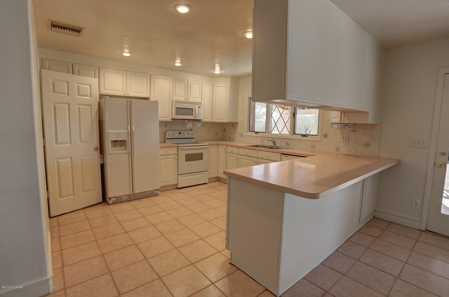 5851 South Avra Road Tucson, AZ 85735 - Photo 2 of 46 a kitchen with stainless steel appliances granite countertop a refrigerator and a sink