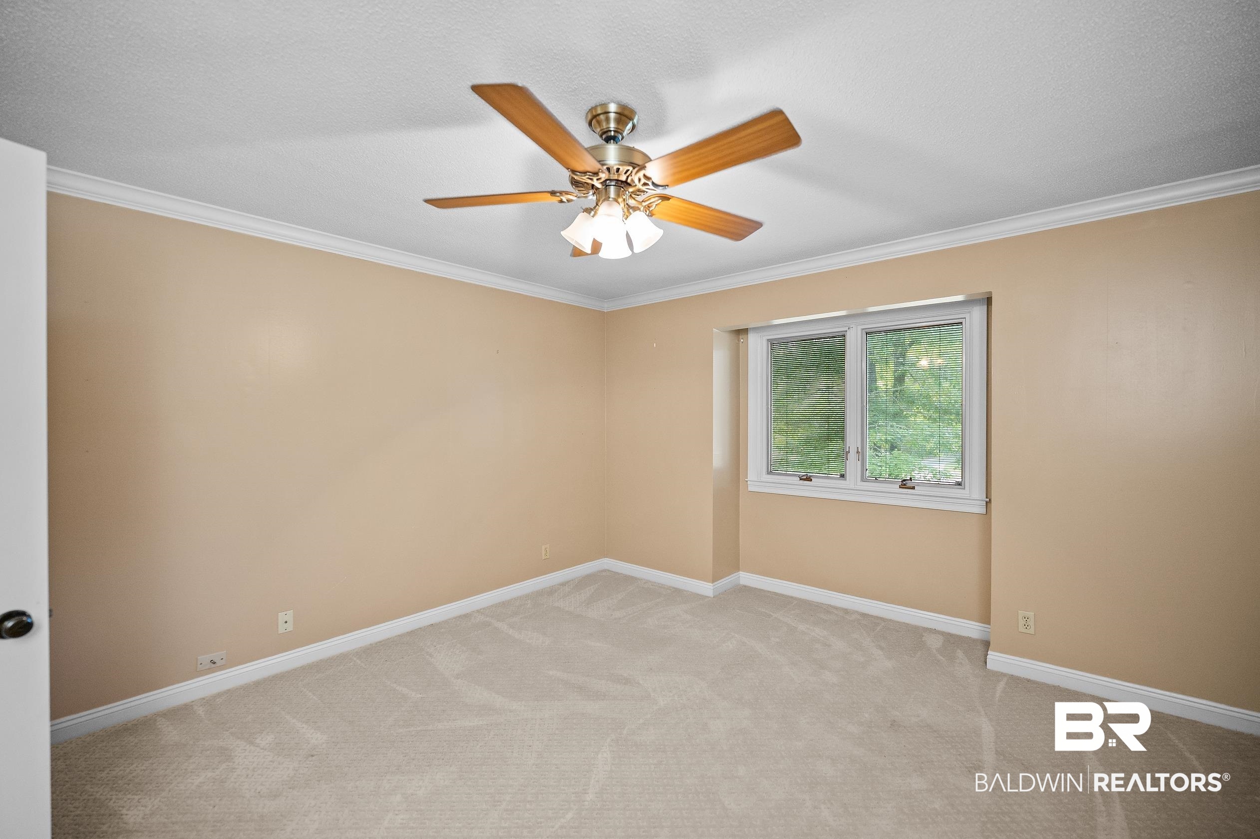 329 Norwood Road Monroeville, AL 36460 - Photo 23 of 49 Carpeted room featuring a ceiling fan with integrated lighting, a window with exterior scenery, crown molding, and baseboards