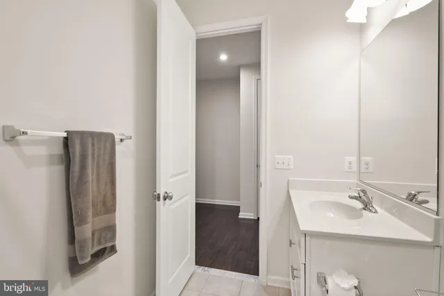a view of a dining room and livingroom with furniture wooden floor a rug a chandelier and a mirror