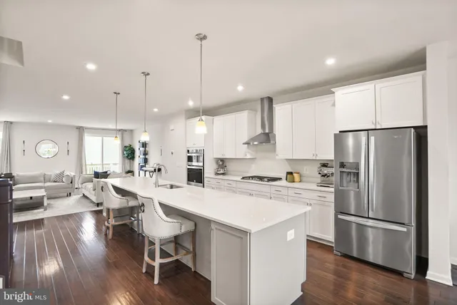 a kitchen with granite countertop a refrigerator a stove a sink a counter space and cabinets