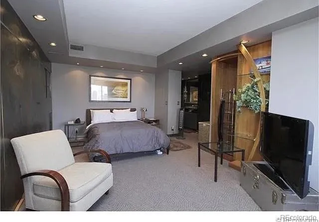 a bedroom with furniture and a flat screen tv