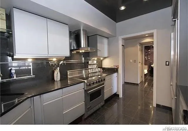 a kitchen with kitchen island granite countertop a sink stainless steel appliances and cabinets