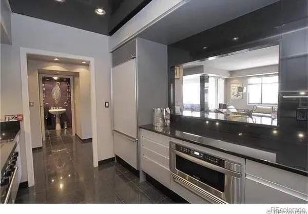 a kitchen with granite countertop a stove and white cabinets