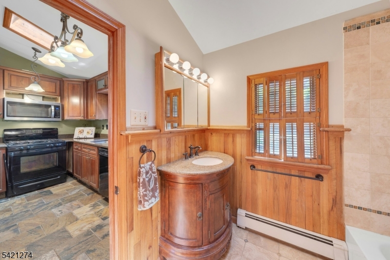 95 Wildwood Road Oak Ridge, NJ 07438 - Photo 11 of 36 a bathroom with a sink a mirror and a window