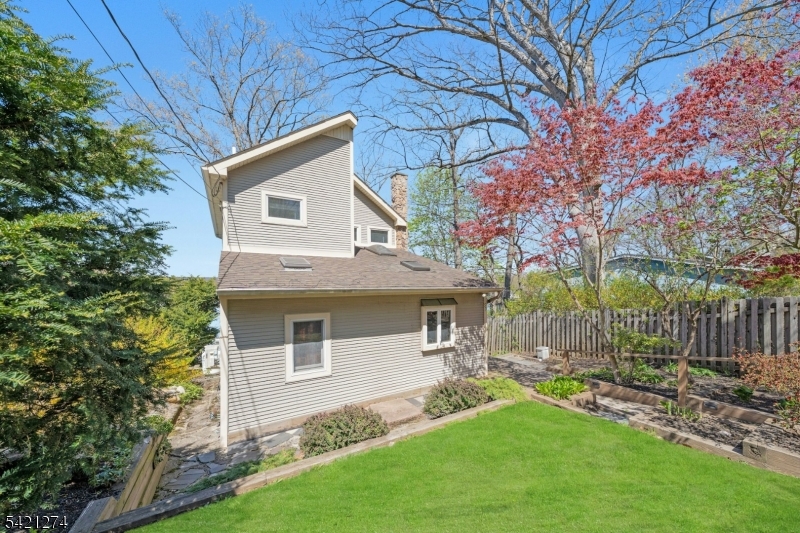 95 Wildwood Road Oak Ridge, NJ 07438 - Photo 2 of 36 a front view of a house with a garden and yard