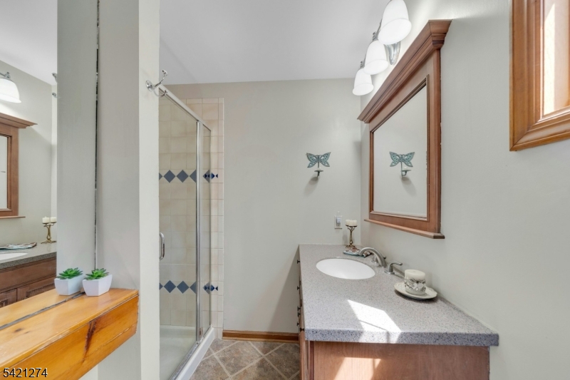95 Wildwood Road Oak Ridge, NJ 07438 - Photo 24 of 36 a bathroom with a granite countertop sink and a mirror