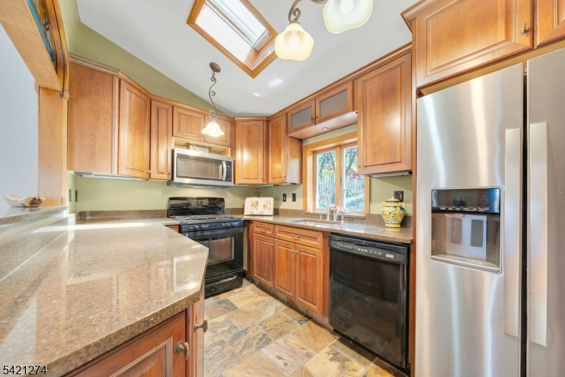 95 Wildwood Road Oak Ridge, NJ 07438 - Photo 9 of 36 a kitchen with stainless steel appliances granite countertop a sink a stove and a refrigerator