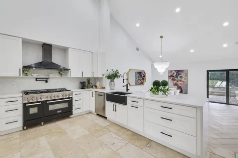 a kitchen with stainless steel appliances kitchen island granite countertop a table and chairs in it