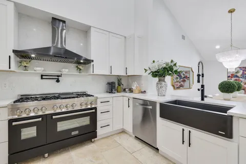 a kitchen with white cabinets and appliances