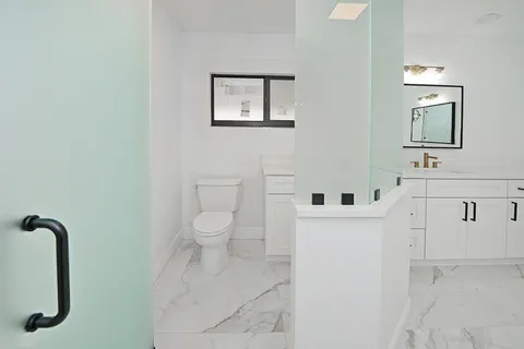 a white toilet sitting next to a bathroom sink