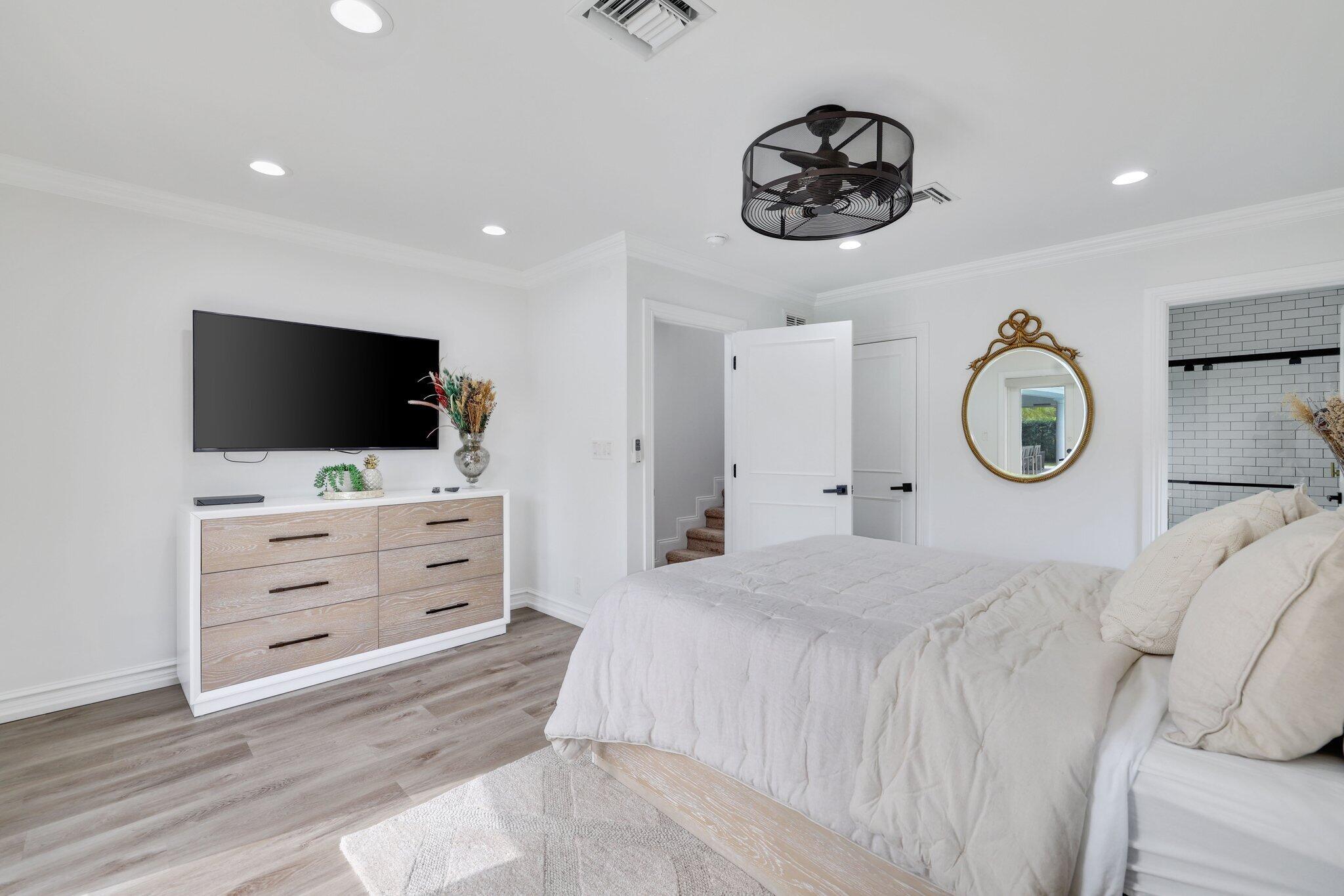 7811 Mandarin Drive Boca Raton, FL 33433 - Photo 35 of 51 a bedroom with a bed a mirror and tv on the wall